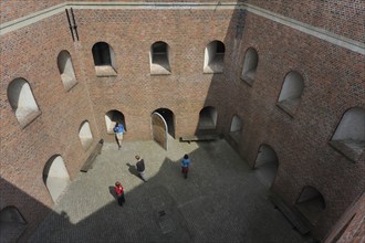 Tourists with audio guides visiting the pentagonal courtyard of Fort Napoleon in Ostend, Belgium,