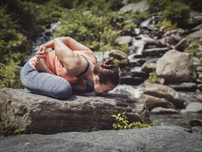 Vintage retro effect filtered hipster style image of Young sporty fit woman doing yoga, meditating