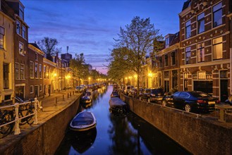 Typical Netherlands view, canal with boats and houses illuminated in the evening. Haarlem,