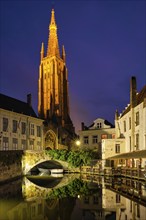 Church of Our Lady and canal illuminated in the night. Brugge Bruges, Belgium, Europe