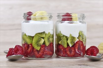 Healthy snack with raw raspberry and kiwi fruits and yoghurt layered in glass