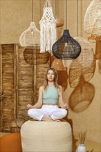 Yoga for senior people. Woman balancing on padded stool in lotus pose