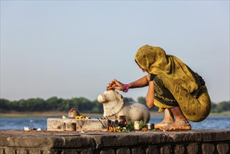 MAHESHWAR, INDIA, APRIL 26: Indian woman performs morning pooja on sacred river Narmada ghats on