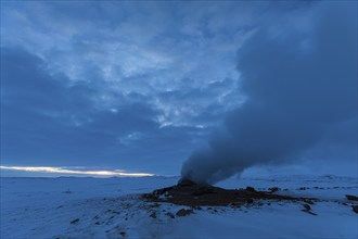 Mud pot with steam source at dawn, Hverir solfatar field, fumaroles, snow-covered geothermal area,