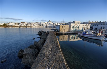 Harbour wall, local view of Naoussa town and blue sea, harbour with fishing boats and reflection,