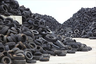 Old car tyres lie on stockpiles for recycling