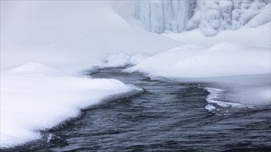 Snow mounds and icicles in the Skoga River below Skogafoss waterfall, Sudurland, Iceland, Europe