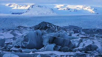 Snow-covered icebergs in the glacier lagoon Jökullsarlon, Breidamerkurjökull in the background,