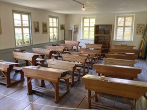 Historic classroom with old-fashioned school desks for school class in village school in old