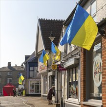 Support for Ukraine, Ukrainian national flags flying outside shops, Saxmundham, Suffolk, England,