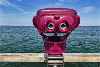 Red telescope on pier, coin telescope points to water, sunny weather, Binz seaside resort, Rügen,