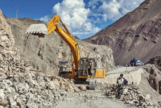 LADAKH, INDIA, SEPTEMBER 10, 2011: Excavator cleaning road after landslide in Himalayas. Ladakh,