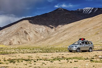 LADAKH, INDIA, SEPTEMBER 8, 2011: Modern MPV car Toyota Innova on road in Himalayas mountains