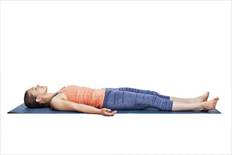 Beautiful sporty fit yogini woman relaxes in yoga asana Savasana, corpse pose in studio