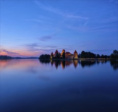 Evening view of Trakai Island Castle in lake Galve illuminated in the night, Lithuania. Square