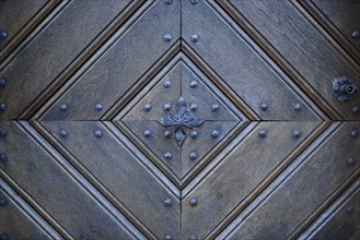 Detail of an old wooden door with traditional metal door knob