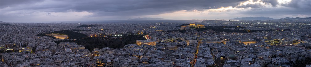 Panorama, view over the sea of houses of Athens, illuminated Parthenon temple on the Acropolis,