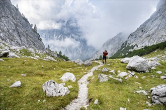 Mountaineer on a hiking trail, cloudy mountains, descent over the Ofental, mountain tour on the