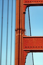 Orange pylon and steel cables of the suspension bridge, detail, Golden Gate Bridge, blue sky, San