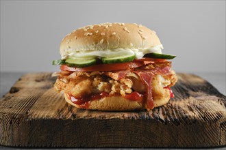 Chicken fresh burger with bacon and fresh cucumber, front view