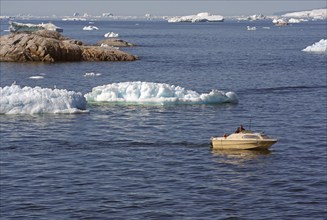 Small boat between icebergs and rocks, Ilulissat, Disko Bay, Denmark, Greenland, North America