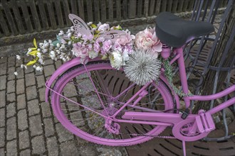 Pink coloured bicycle decorated with artificial flowers, Bavaria, Germany, Europe