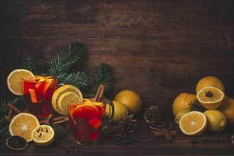 Two glass cups with punch, oranges, lemons, spices, Christmassy, wooden background, copy room