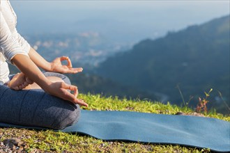 Meditation relaxation concept background, close up of woman in Padmasana yoga lotus pose with chin