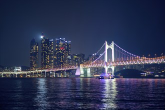 Gwangan Bridge and skyscrapers illuminated in the night. Busan, South Korea, Asia