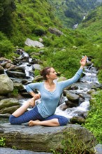 Hatha yoga outdoors, young sporty fit woman doing yoga asana Eka pada rajakapotasana, one-legged