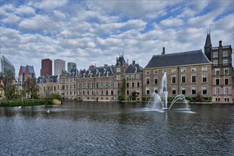 View of the Binnenhof House of Parliament and the Hofvijver lake with downtown skyscrapers in