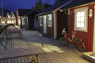 Cosy wooden hut in the evening light, bicycle standing in front of it, holiday, cycle trip, Halsa,