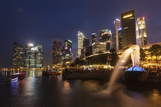 SINGAPORE, JANUARY 1, 2014: Night view of Singapore Merlion at Marina Bay against Singapore skyline