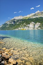 View from the shore of Lake Walen of the small chive island in the middle of the turquoise water at