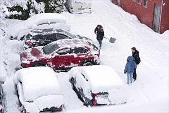 Woman shovelling snow on car park, car, car, snowed in, fresh snow, heavy snowfall, snow masses,