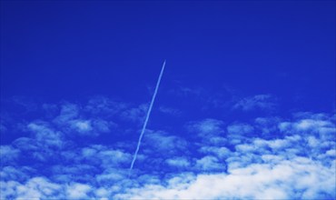 Aeroplane with contrails in the cloudy sky, Austria, Europe