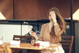 Beautiful young woman has coffee break in the middle of sunny day