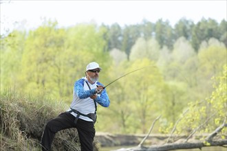 Fisherman trying to do a perfect cast, throwing lure. Spining fishing, angling, catching fish.