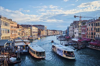 VENICE, ITALY, JUNE 27, 2018: Grand Canal with boats, vaporetto and gondolas on sunset from Rialto