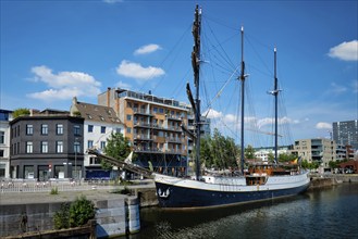 Ship moored in Willemdock in Antwerp. View of Bonapartedok harbor and vintage galleon. Antwerpen,