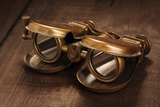 Vintage opera glasses binoculars on old wooden background