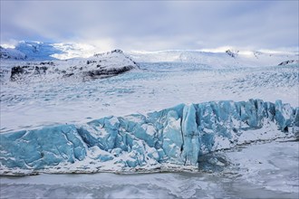 Snow-covered icebergs in the Fjallsarlon glacier lagoon, with the Öraefajökull glacier behind,