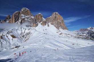 View of a ski resort piste with people skiing in Dolomites in Italy