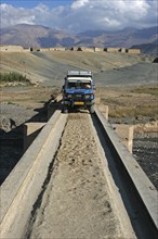 Four-wheel drive vehicle, 4×4 jeep crossing a narrow bridge in the Atlas Mountains, Morocco, North