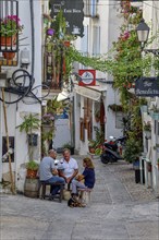 People in a sidewalk café in the old town of Peñíscola, Castellón province, Costa del Azahar,