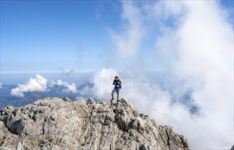 Mountaineer on a rocky narrow mountain path with mountain panorama, mountain tour to the summit of