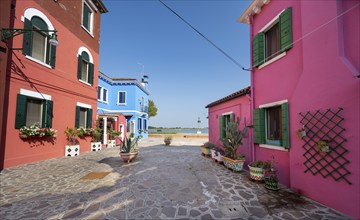 Colourful houses with flowers and clothesline, colourful house facades, alleys on the island of