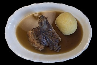 Schäuferle with dumpling on black background, Bavaria, Germany, Europe