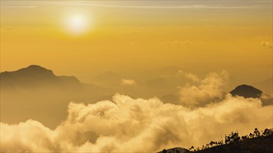 Panorama of mountains in clouds on sunset