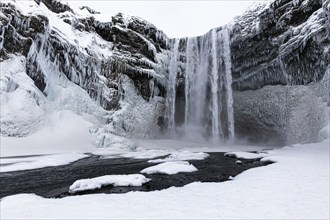 Skogafoss waterfall, snowy and icy rock face, Sudurland, Iceland, Europe